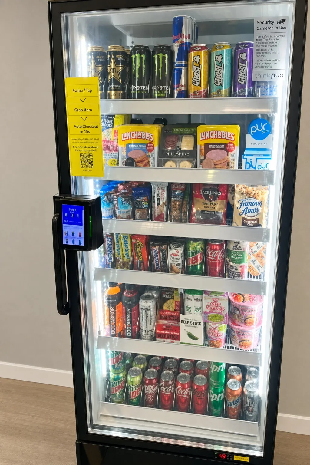 OSO Vending smart cooler with a tap-to-enter card reader, stocked with energy drinks, Lunchables, snacks and cold sodas — swipe, grab what you want, and the door charges you automatically